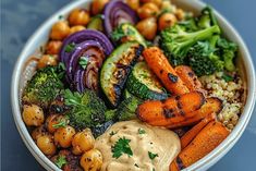 a bowl filled with carrots, broccoli and other vegetables