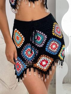 a close up of a person wearing shorts with crocheted designs on the bottom