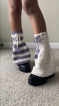 the legs of a person wearing crocheted socks and slippers on top of carpet