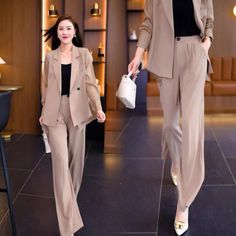 two women in tan suits walking down a black tile floored hallway, one carrying a white purse and the other wearing gold shoes