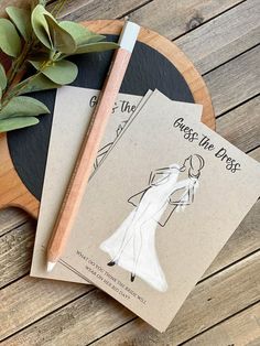 two book covers on a wooden table next to a knife and some green plant leaves