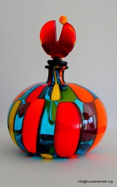 a multicolored glass vase sitting on top of a table