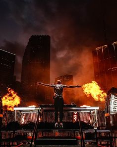 a man standing on top of a stage surrounded by fire