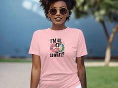 a woman wearing a pink t - shirt that says i'm mad so what?