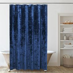 a bath room with a tub and a shower curtain that has blue velvet on it