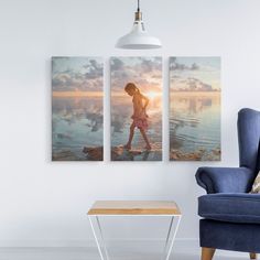 two pictures hanging on the wall next to a blue chair and a small table in front of it