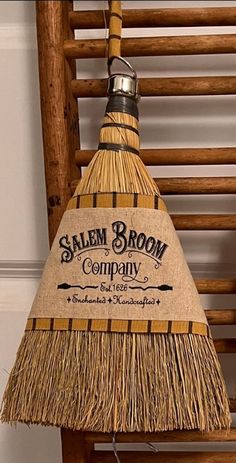 a wooden chair with a broom hanging from it's side and the name salem broom company on it