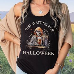 Be ready for the spooky season with this Skeleton, Coffee, Halloween Tank Top featuring a skeleton sipping coffee and the playful phrase, 'Just waiting for Halloween'. A funny gift for coffee lovers and Halloween enthusiasts alike. This tank top adds a touch of humor to your fall wardrobe.  *Shirt colors may appear slightly different on different computer screens. I strive my best to give you the most accurate pictures of shirt colors. I apologize if they look slightly different in real life. *M Gothic Skull Print Tops For Halloween, Gothic Halloween Skull Print Tops, Casual Halloween Skull Print Tank Top, Waiting For Halloween, Skeleton Coffee, Halloween Tank Top, Coffee Halloween, Sipping Coffee, Coffee Shirt