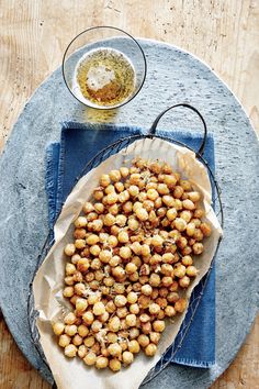 a blue plate topped with roasted chickpeas next to a bowl of seasoning