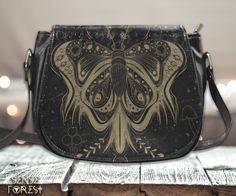 "Boho Moon Moth Vegan leather Goth saddle bag, Boho witchy crossed body purse, cute PU leather hand bag goth bag, dark kawaii goth purse gift Type: High-grade PU Leather, 9.05\"(L) x 3.35\"(W) x 7.48\"(H) .: 16.97 Oz. Made from high-grade PU leather with gold-tone hardware. .: Single zippered top inside closure, flap front closure with magnetic snap closure. .:Inner zipper pocket on back wall and a back zipper pocket. .:Cross body shoulder strap with adjustable length. .:Dimensions: 9.05\"(L) x Gothic Brown Bag For Everyday Use, Gothic Brown Bag, Gothic Black Shoulder Bag For Festivals, Gothic Black Shoulder Bag Gift, Black Gothic Shoulder Bag For Gift, Black Gothic Shoulder Bag As Gift, Black Bohemian Shoulder Bag Gift, Handmade Black Satchel As Gift, Gift Black Saddle Bag With Adjustable Strap