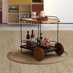 a coffee table with drinks on it sitting in front of a book shelf and bookshelf