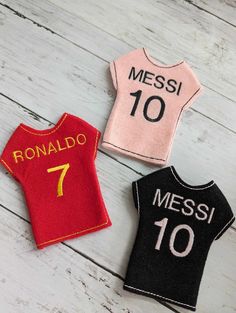 three different types of t - shirts on a white wooden surface, one with the number seven