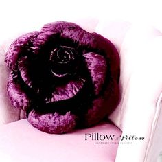 a large purple flower sitting on top of a white chair