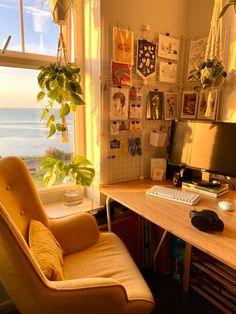 a computer desk with a keyboard and mouse in front of a window overlooking the ocean