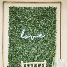 a chair sitting in front of a green wall with the word love written on it