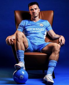 a man sitting in a chair with a soccer ball