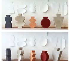 several different shapes and sizes of vases on the shelf in front of a wall