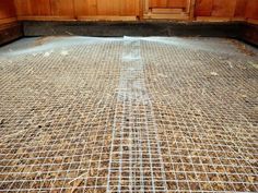 a metal grate sitting on top of a floor covered in dirt and wood planks