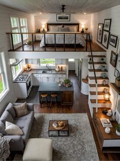 a living room and kitchen with stairs leading up to the loft bed in this small home