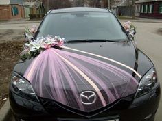 a black car decorated with flowers and ribbons