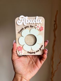 a hand holding up a small card with flowers on it that says, abuuela make you for happiness now