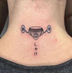 a woman's lower back neck with an upside down tattoo on her left side