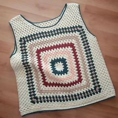 a crocheted tank top sitting on the floor