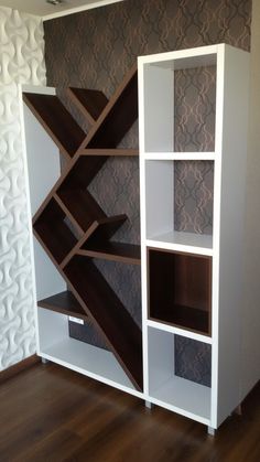 a white book shelf sitting on top of a hard wood floor next to a wall