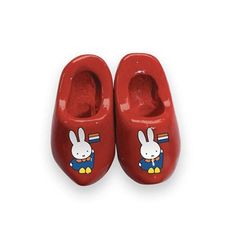 a pair of red baby shoes with cartoon characters on the front and back, sitting next to each other