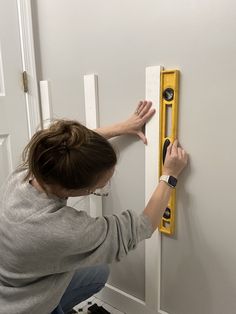 a woman is working on a door handle