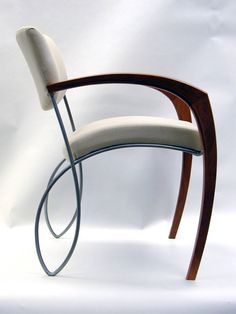 a chair with a curved back and arm rests against a white background, while the seat is bent to the side