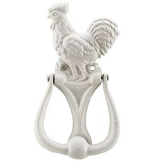 a white rooster figurine sitting on top of a hook