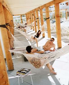 three people sitting in hammocks on the porch with their feet propped up and reading