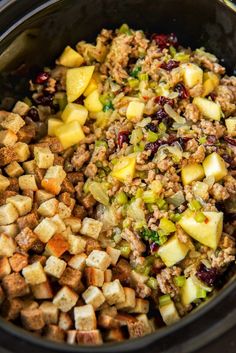 a crock pot filled with stuffing, apples and other food items to be cooked in