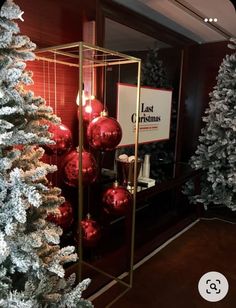 christmas trees are lined up with red and silver ornaments