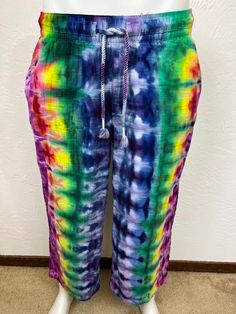 Ice tie dye large sized women's soft pants. High-waisted pants sit at belly button. Relaxed through the hip and thigh. Wide leg, and will hit above the ankle. Elasticized waistband with drawstring fastening. On-seam diagonal side pockets and back patch pockets. Made from 100% textured cotton, is machine wash cold with dark colors, machine dry low. Super comfy, great for festivals or just hangin out at home! Measurements are garment laid out flat  17 inches from waist edge to edge at top 12 inches from top of waistline to crotch  24 inch inseam  22 inches side to side at hips Bohemian Drawstring Trousers, Multicolor Relaxed Fit Bottoms With Drawstring, Tie Dye Cotton Hippie Bottoms, Casual Stretch Tie Dye Bottoms, Summer Harem Pants With Drawstring, Hippie Tie Dye Cotton Bottoms, Casual Stretch Tie Dye Pants, Hippie Cotton Tie-dye Bottoms, Bohemian Drawstring Pants For Loungewear