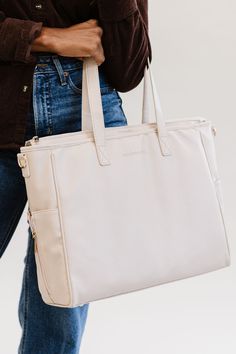 Simplify life on the go with a modern+chic exclusive: The Signature Tote. Chic, versatile, and functional, we designed this vegan leather tote with your busy lifestyle in mind. The ultimate multi-hyphenate, The Signature Tote can be used for anything— commuting, travel, a diaper bag, or an everyday tote. With organization galore, everything will have a place in this spacious carryall. On the outside, you'll find two side pockets, (ideal for baby bottles and small beverages), plus a sleek luggage Trendy Everyday Diaper Bag Tote, Versatile Diaper Bag With Zipper For On-the-go, Versatile Diaper Bag With Zipper Closure For On-the-go, Versatile Tote Diaper Bag, Modern Diaper Bag With Zipper Closure, Everyday Leather Diaper Bag With Zipper, Everyday Leather Diaper Bag With Zipper Closure, Versatile Everyday Diaper Bag With Zipper Pocket, Trendy Everyday Diaper Bag With Zipper Closure