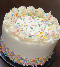 a cake with white frosting and sprinkles