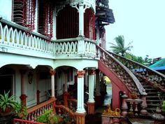 an old house with red railings and white balconies