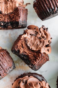 several chocolate cupcakes with frosting on top