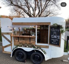 the food truck is decorated with flowers and greenery