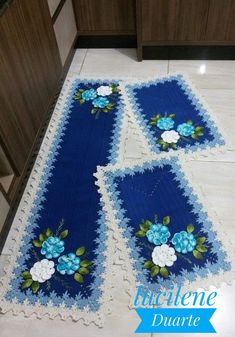 blue and white table runner with flowers on it in the middle of a kitchen floor