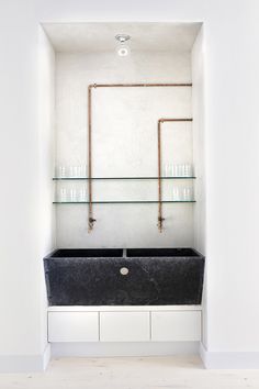 a black and white bathroom with glass shelves