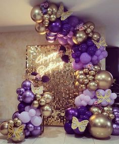 purple and gold balloon arch with happy birthday sign