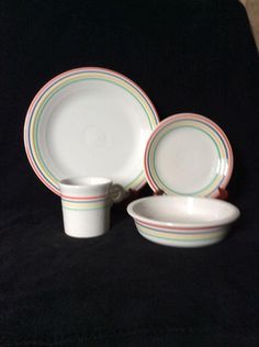 three plates and two cups on a black surface