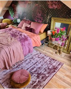 a bedroom with pink and purple decor on the walls, rugs and bedding