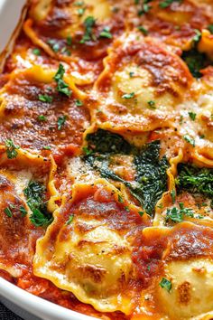 a casserole dish with spinach, cheese and sauce in it on a table