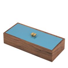 a wooden box with a blue surface and two gold squares on the top, sitting in front of a white background