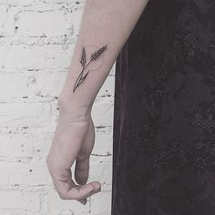 a woman's hand with a small tattoo on the left arm and an arrow in the middle