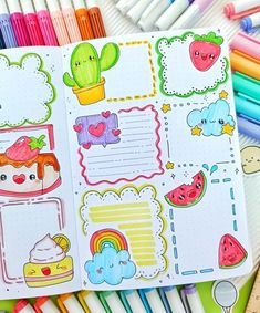 an open notebook with stickers and pens on it next to markers, pencils and crayons